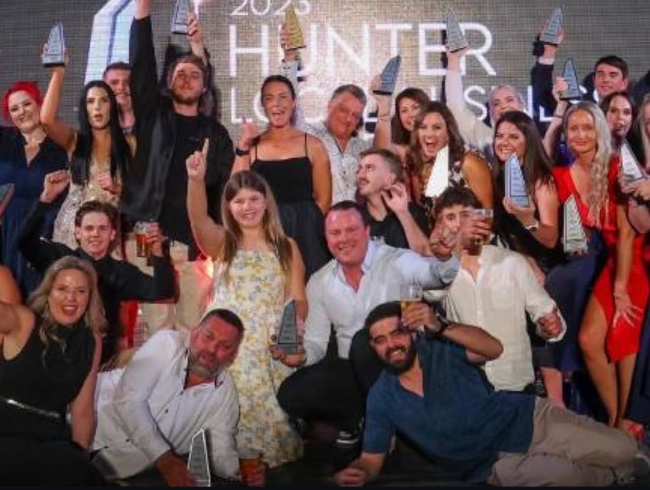 Group of people celebrating, holding awards, at the Hunter Local Skill awards 2023 event.