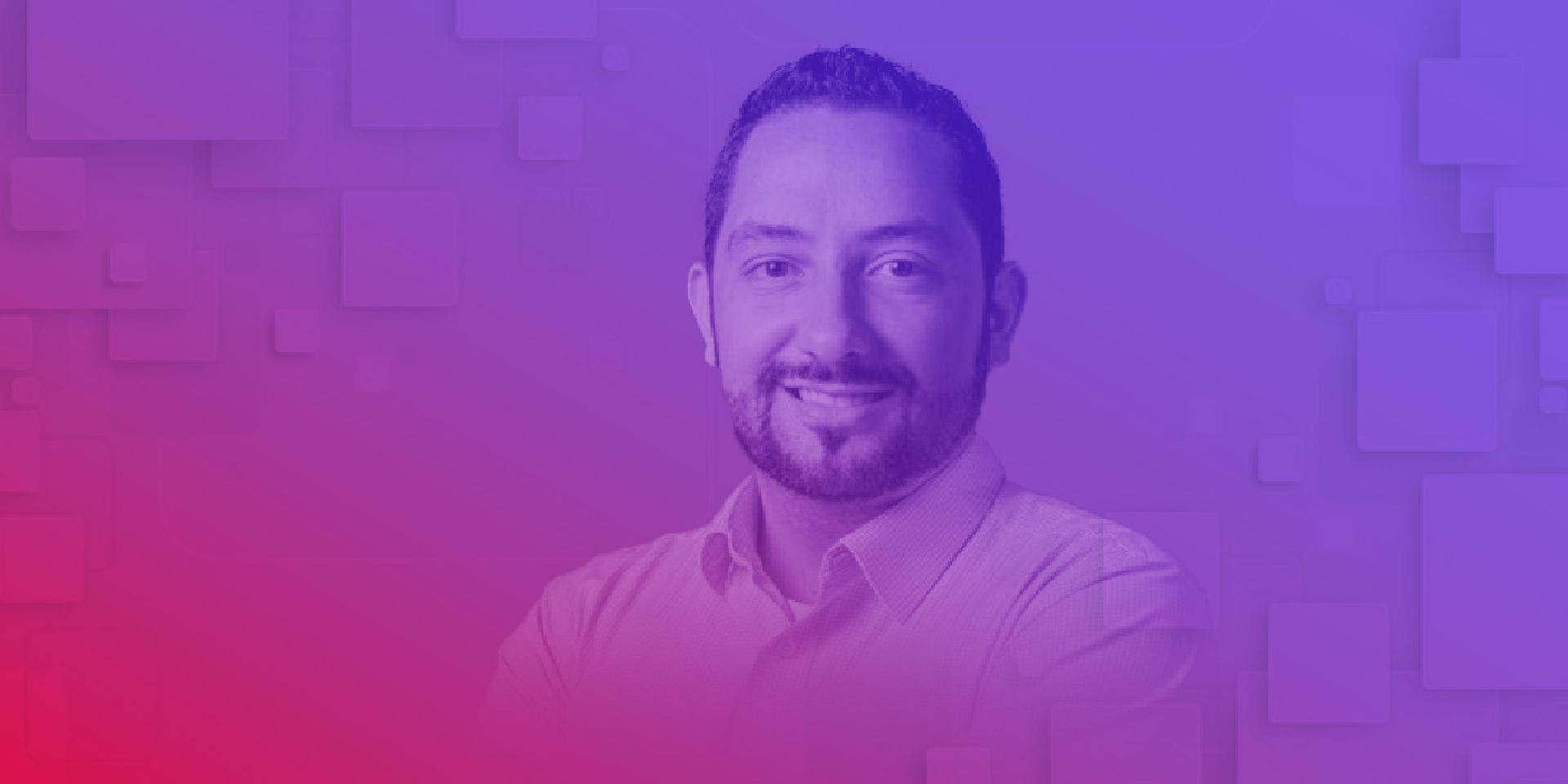 Um homem com barba está sorrindo em frente a um fundo roxo e vermelho.