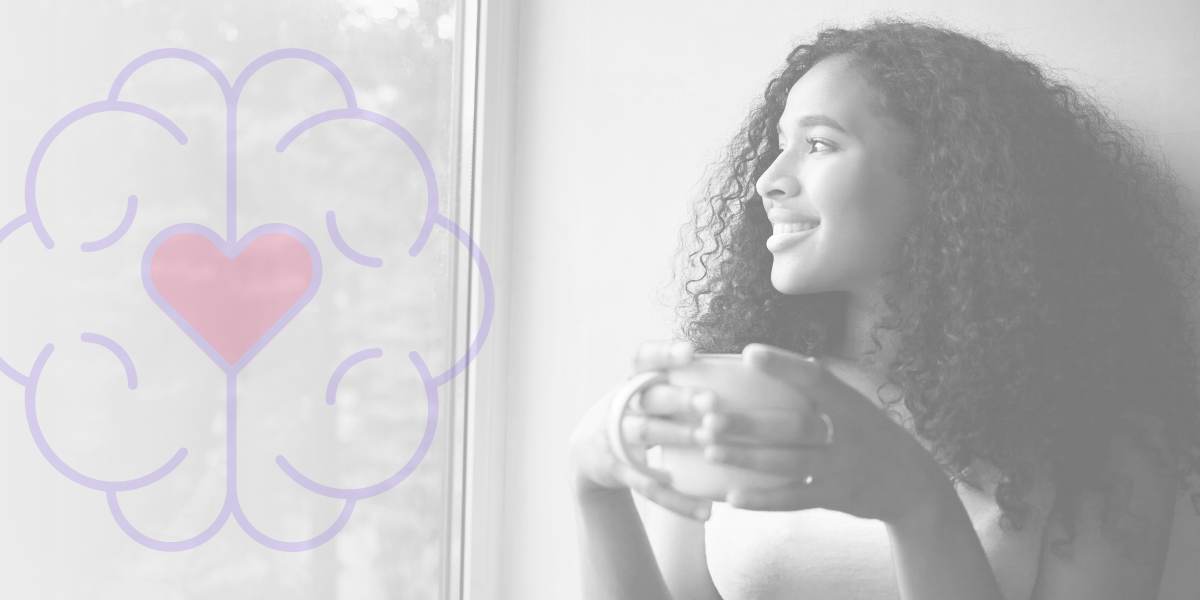 Uma mulher está segurando uma xícara de café e olhando pela janela.