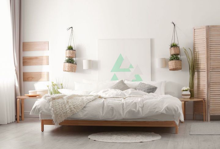 Bright, modern bedroom with a bed centered beneath hanging plants, wooden accents, and a folding screen.