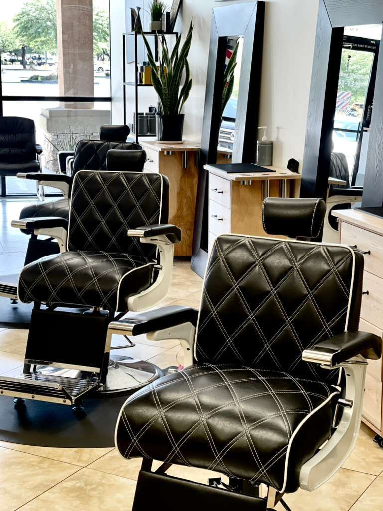 Barber shop interior with black and white barber chairs and mirrors.
