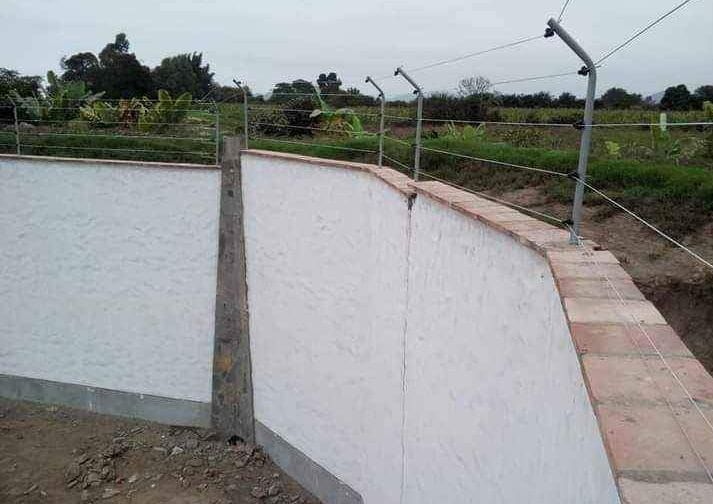 Escalera de metal negra en el lateral de un edificio de hormigón con puerta y escaleras abiertas.