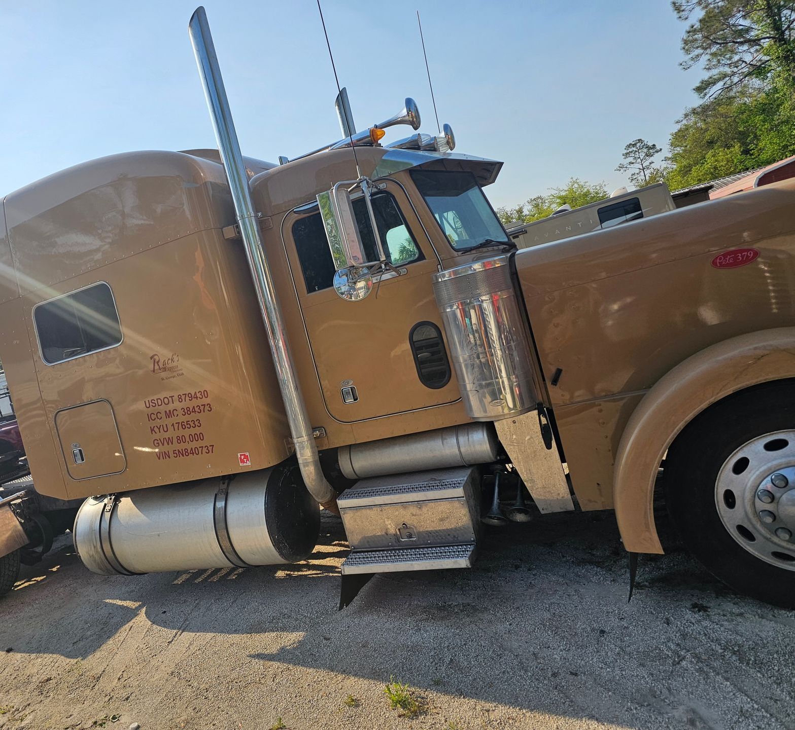 A brown semi truck is parked on the side of the road.
