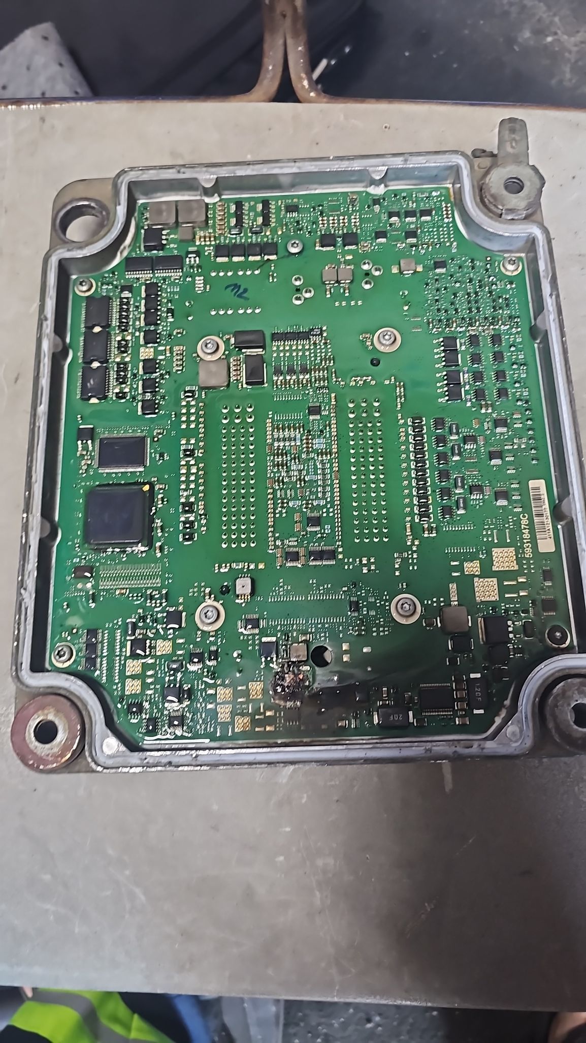 A green motherboard is sitting on top of a table.