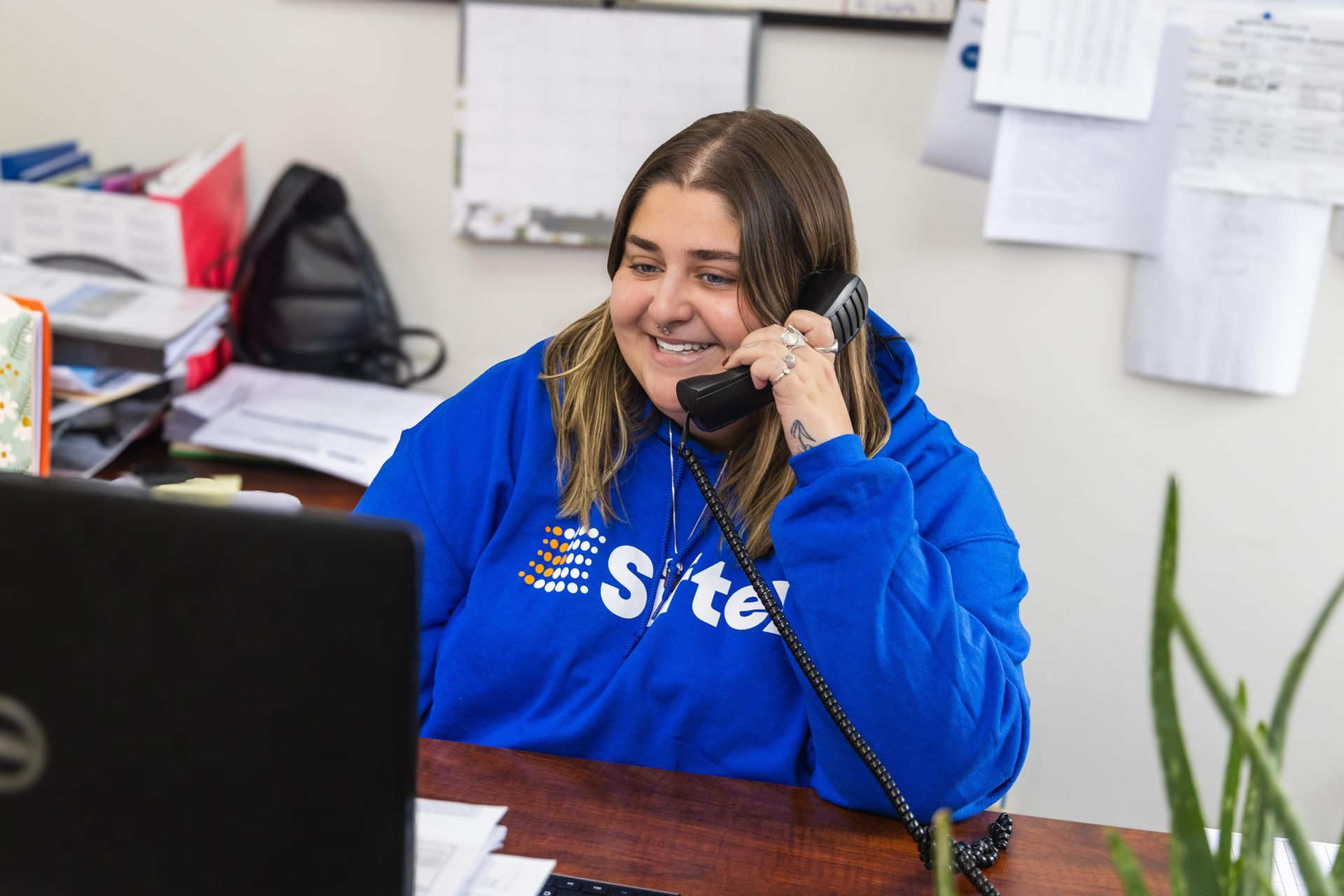 A Siftex employee smiling while talking on the phone
