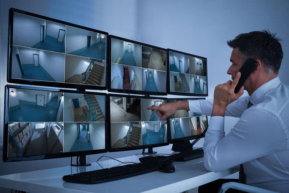 Man monitoring building with CCTV — Cabling services in Manunda, QLD