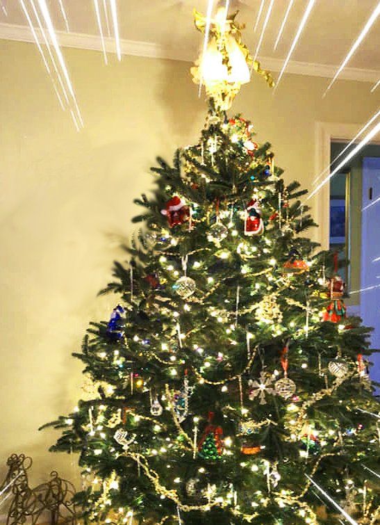 A christmas tree with a chandelier hanging from the ceiling