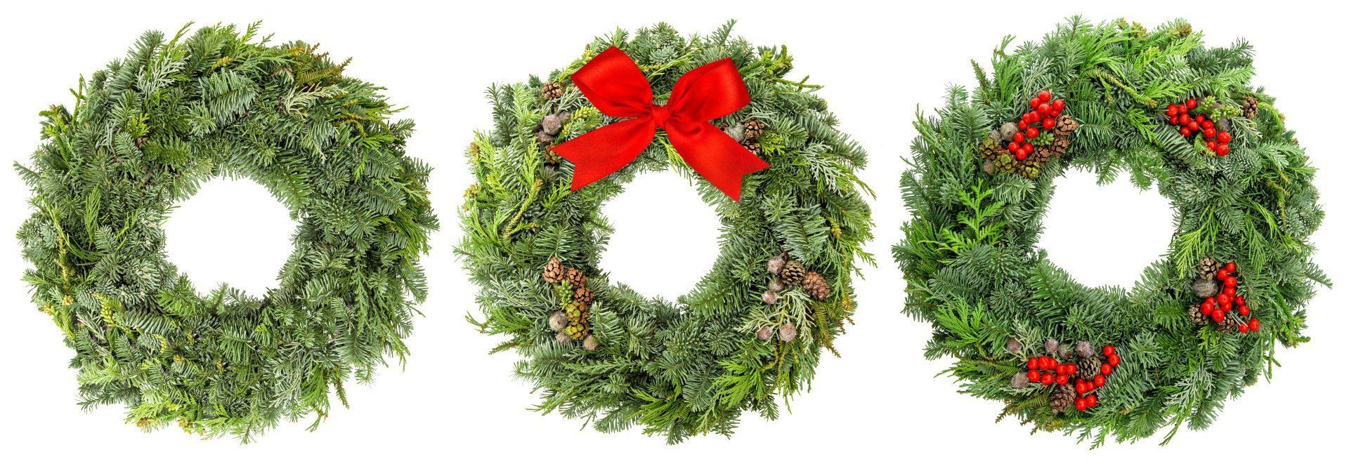 Three christmas wreaths with a red bow on a white background.