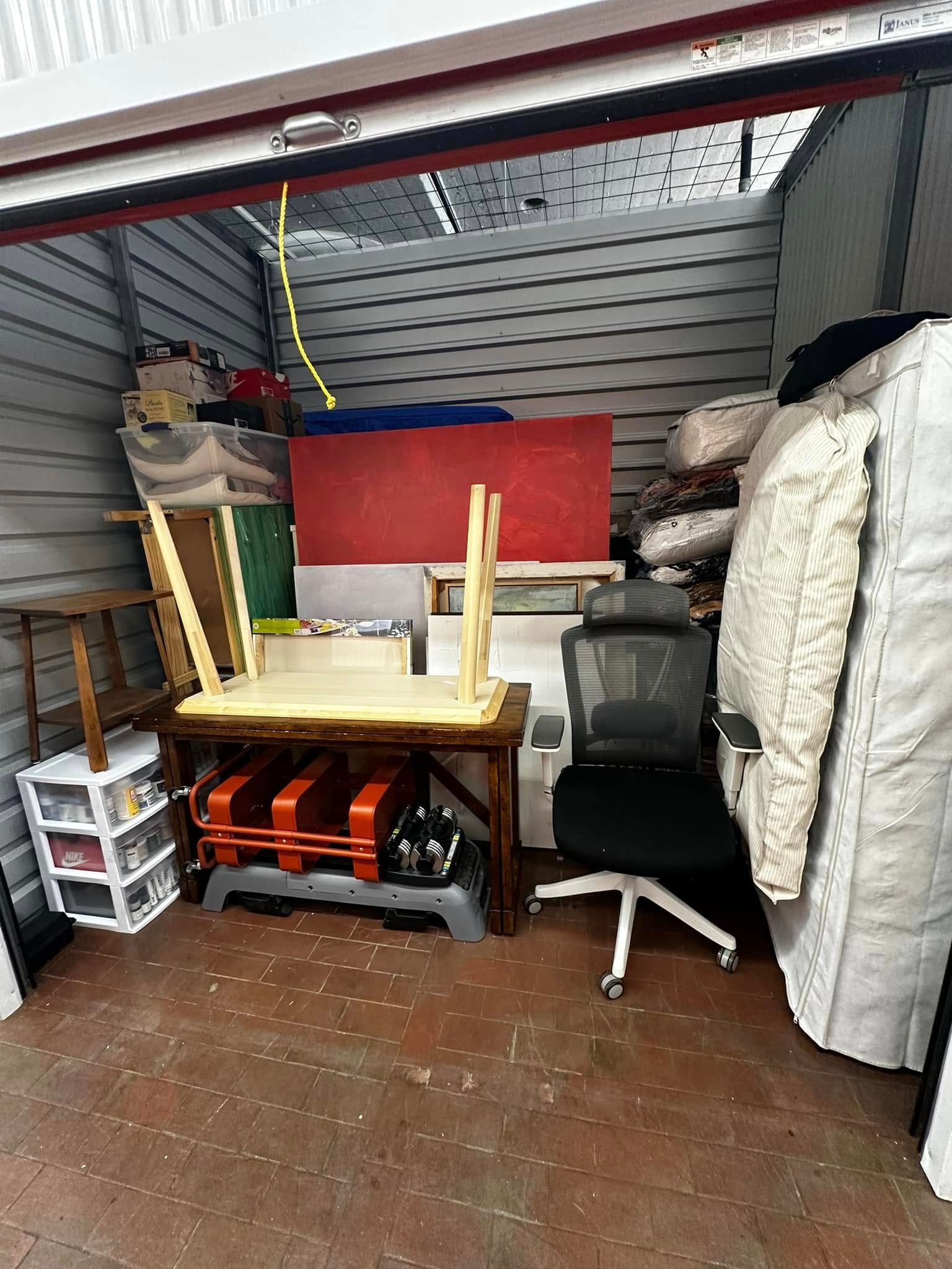 Storage unit filled with furniture, boxes, and other items.