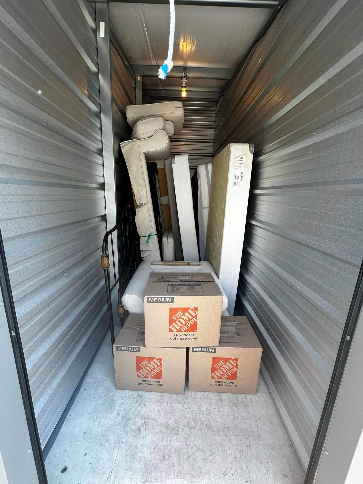 Storage unit packed with boxes and various items.