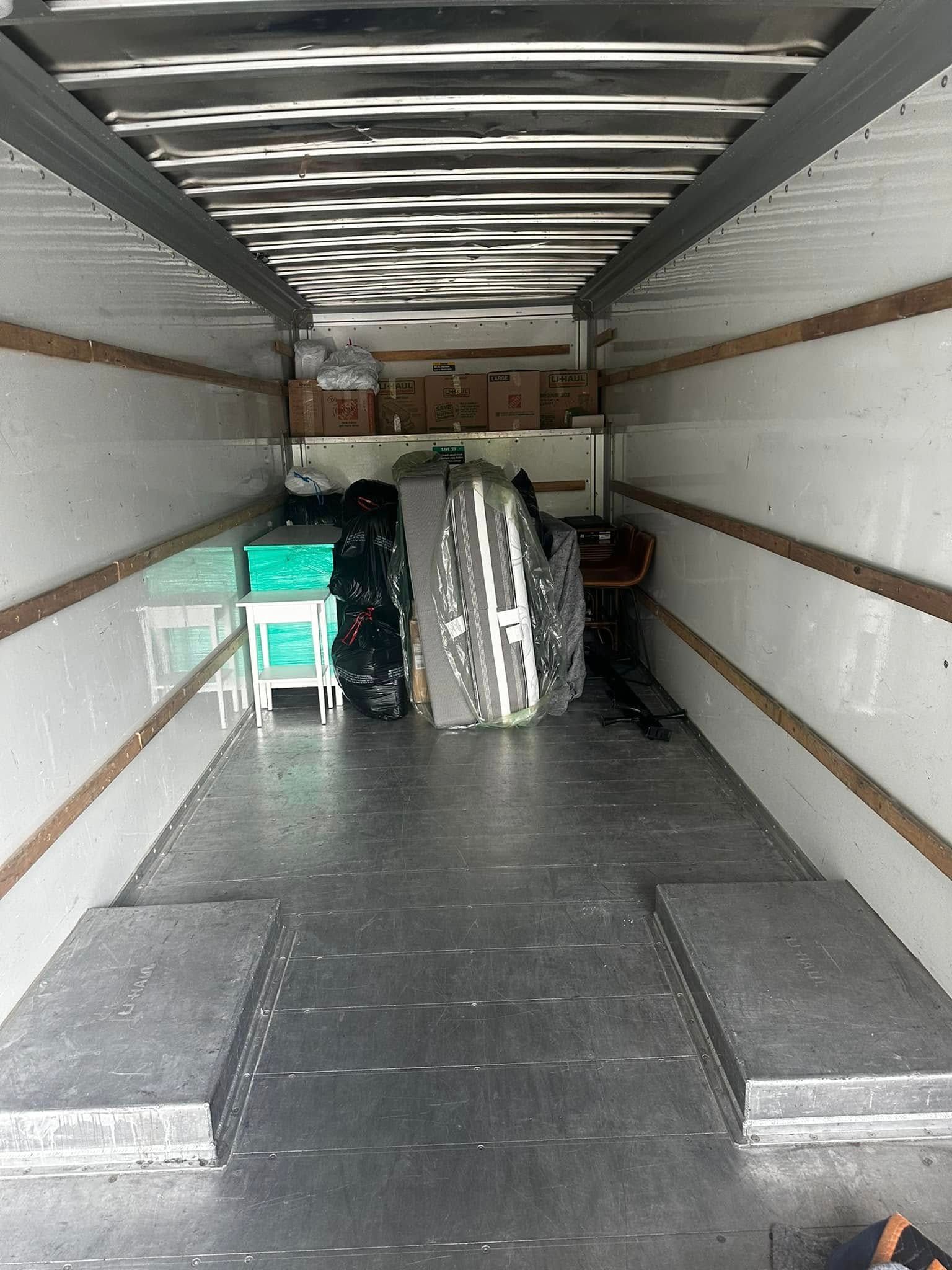Interior of a moving truck, partially loaded with boxes and furniture.