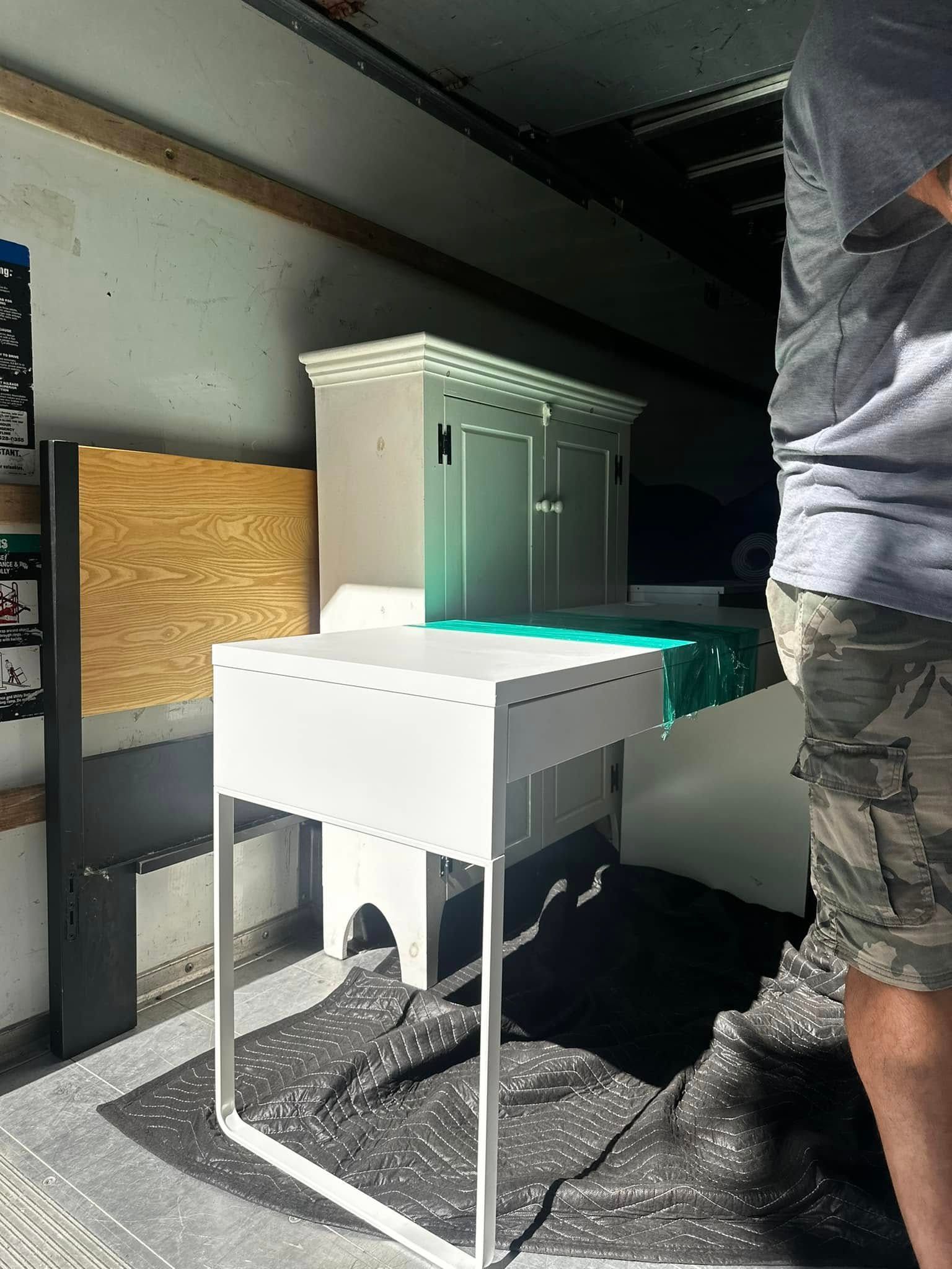 A person next to a white table with a model building on top, indoors with a garage door.