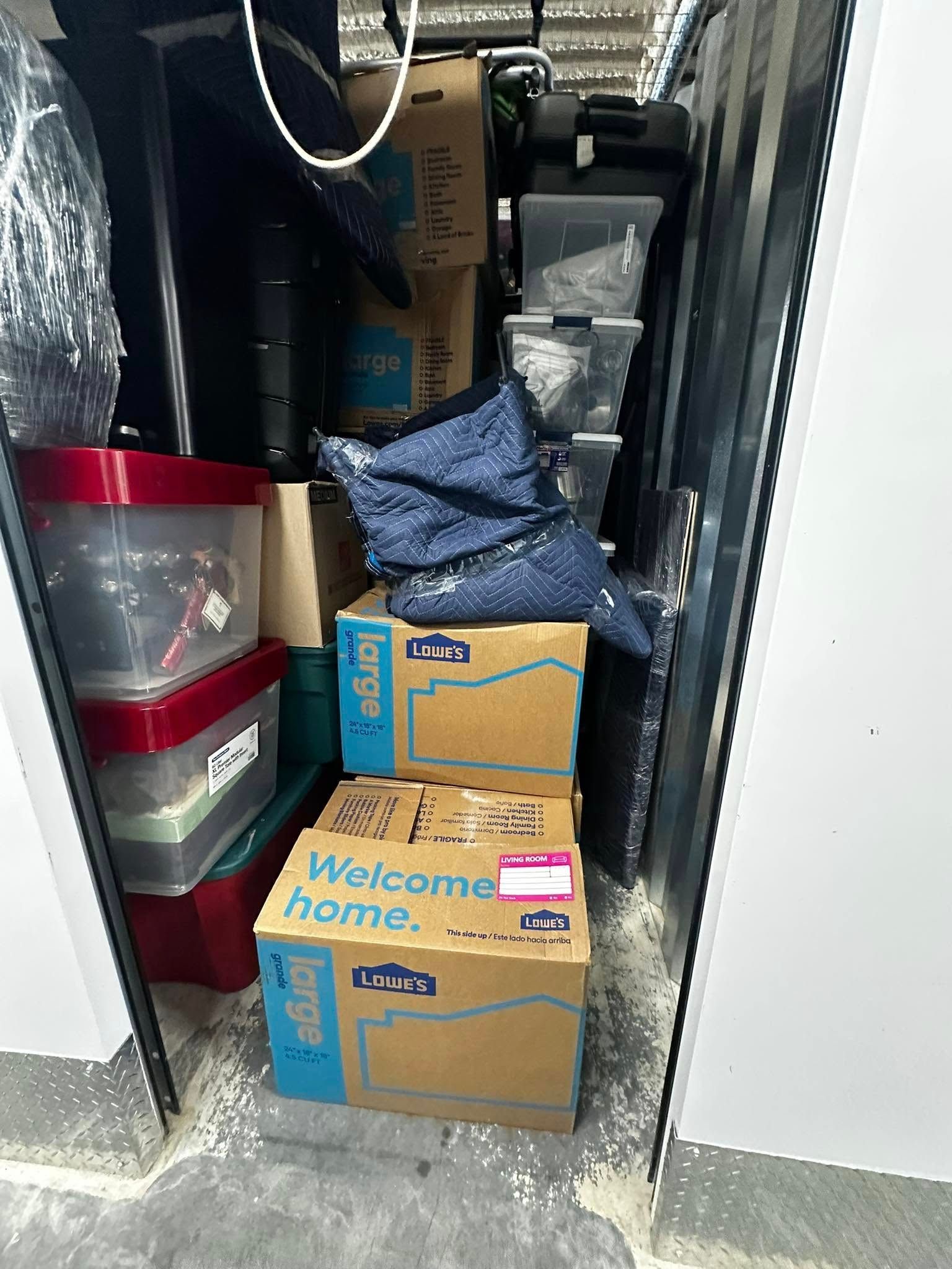 Storage unit filled with boxes, bins, and a pair of blue sequined boots.