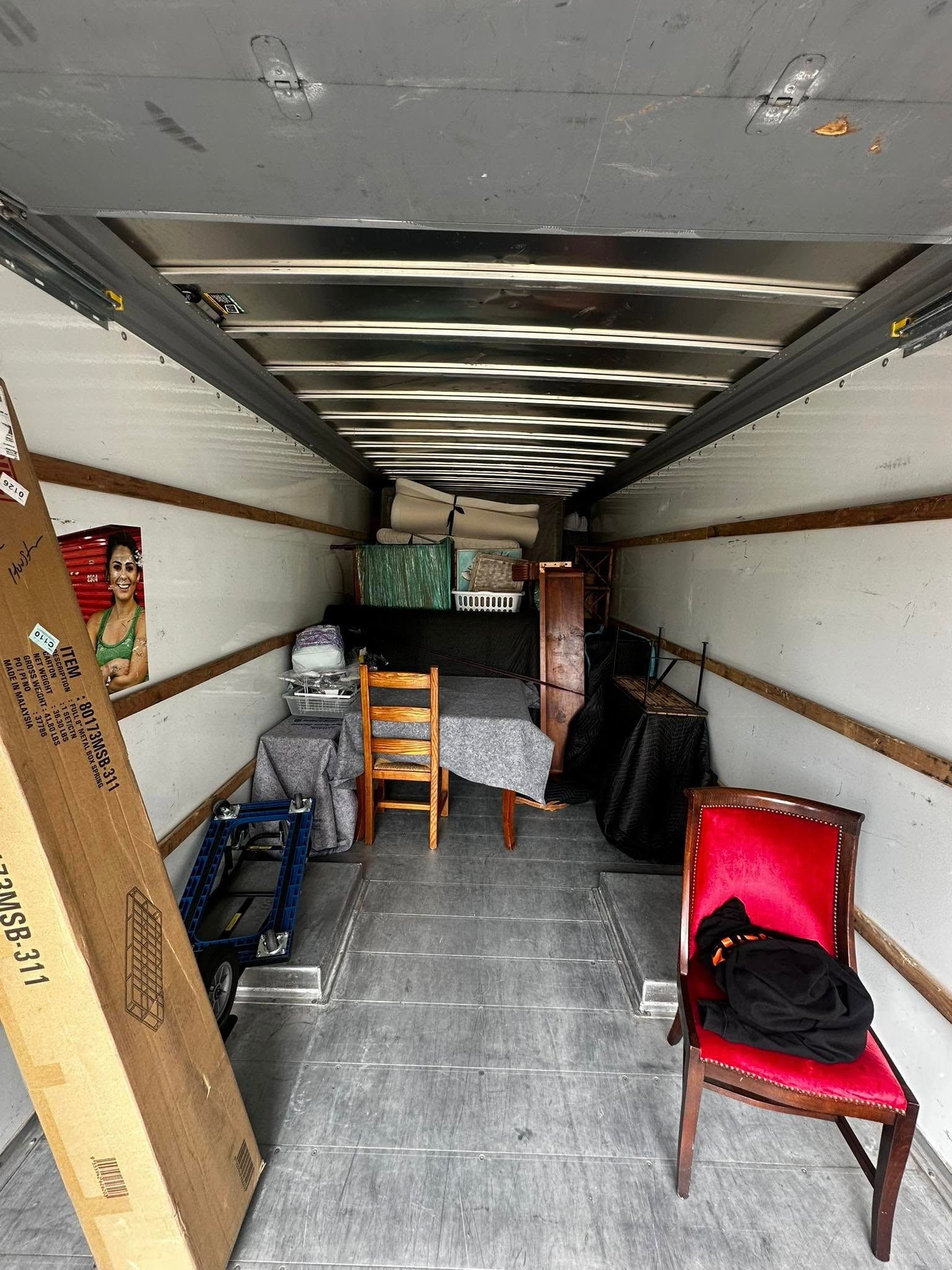 Interior of a moving truck, partly loaded with furniture and boxes.