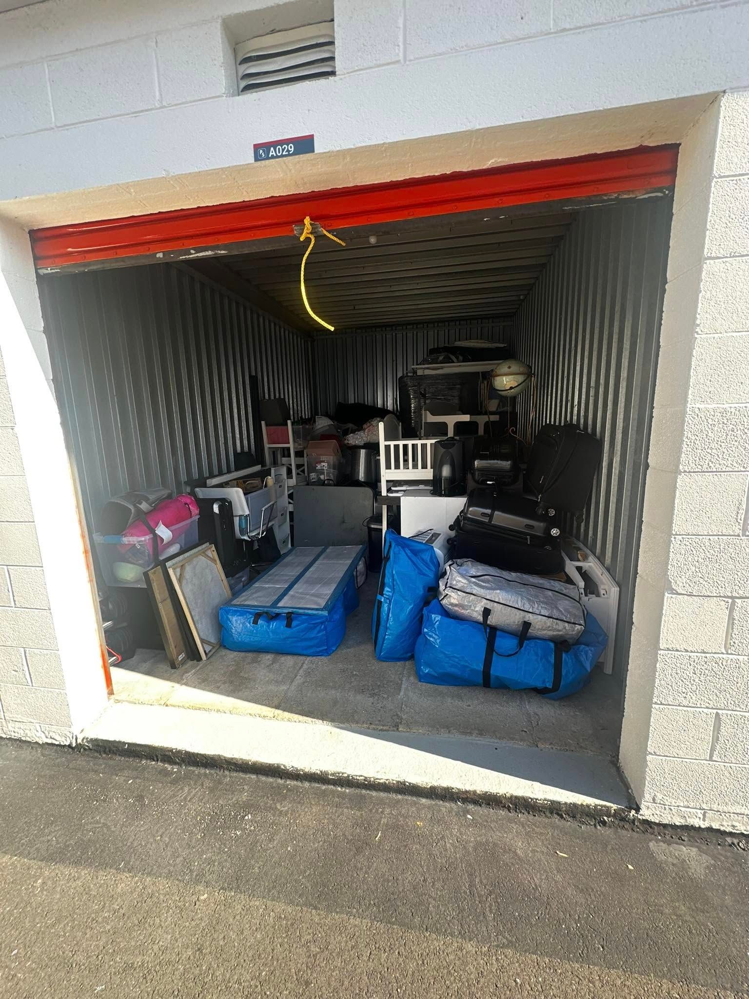 Storage unit packed with furniture and boxes.