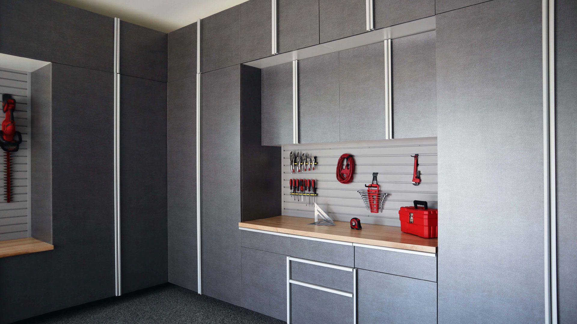 a garage with gray cabinets and a wooden counter top .