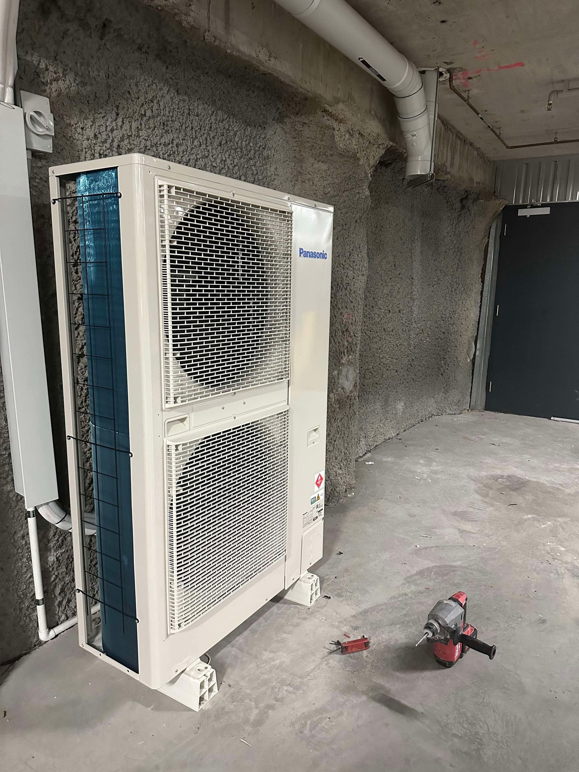 A large air conditioner is sitting on the floor in a room.