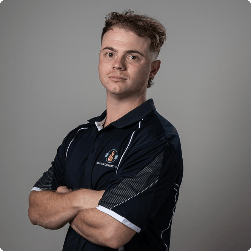 A young man in a blue shirt with his arms crossed