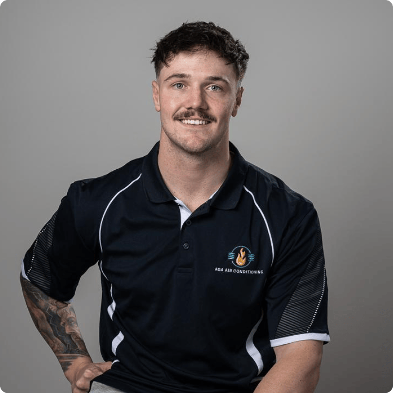 A man with a mustache and a tattoo on his arm is wearing a blue polo shirt.