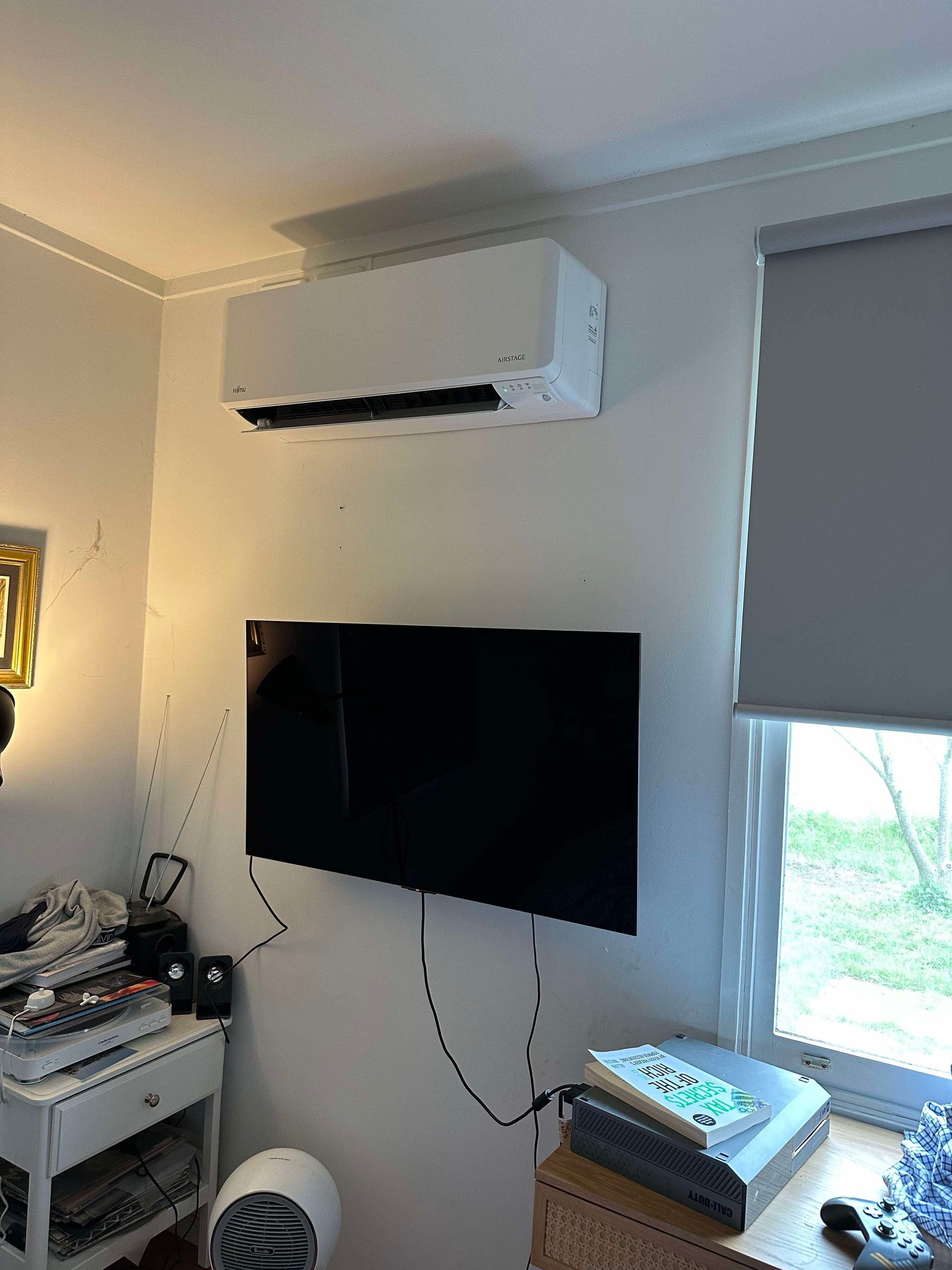 A room with a flat screen tv hanging on the wall.