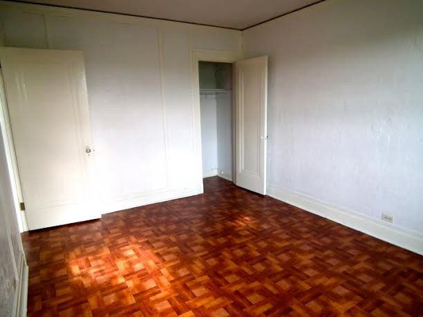 Empty room with wooden floor, white walls, two doors, and closet.
