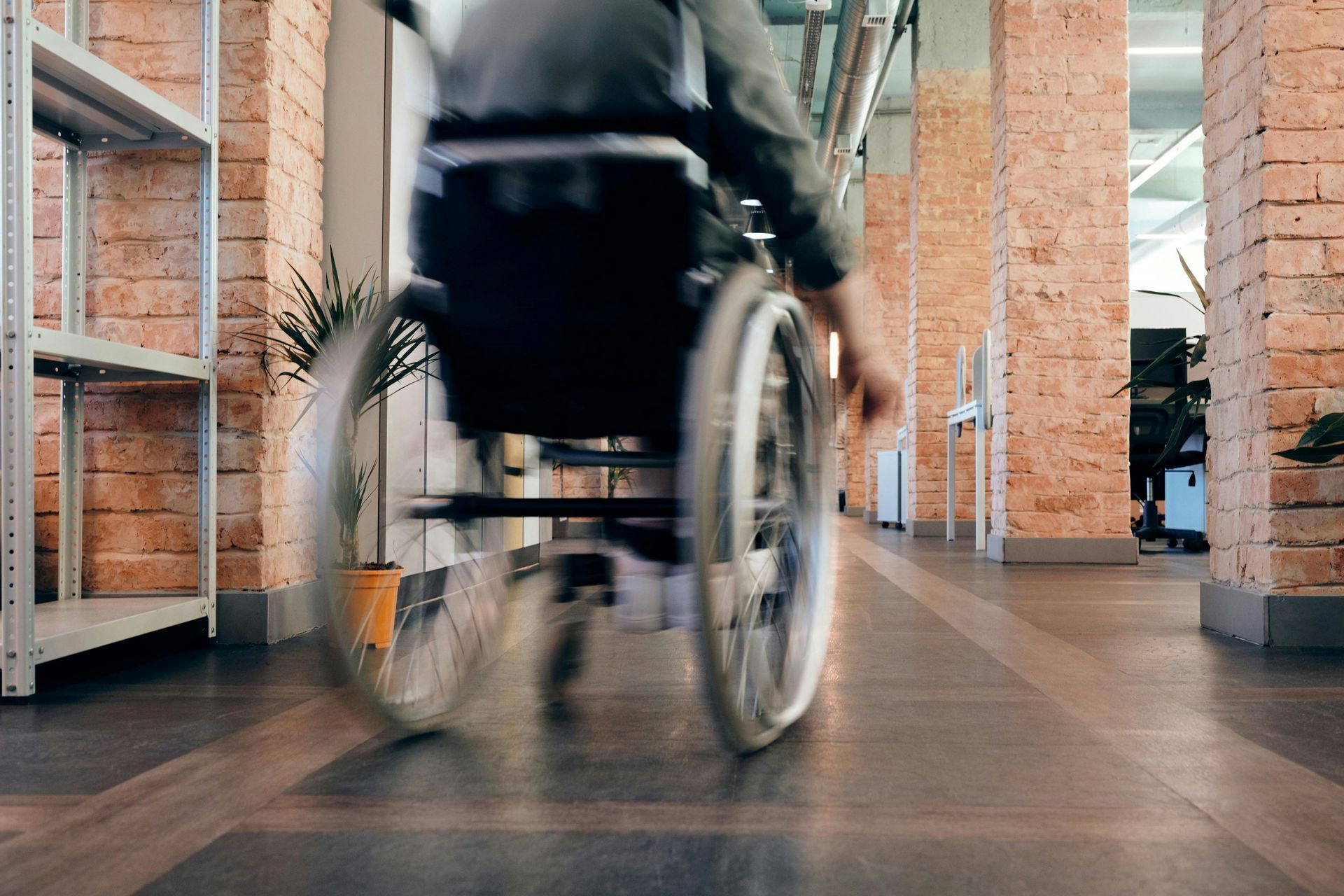 A person on a wheelchair in a middle of a hallway.