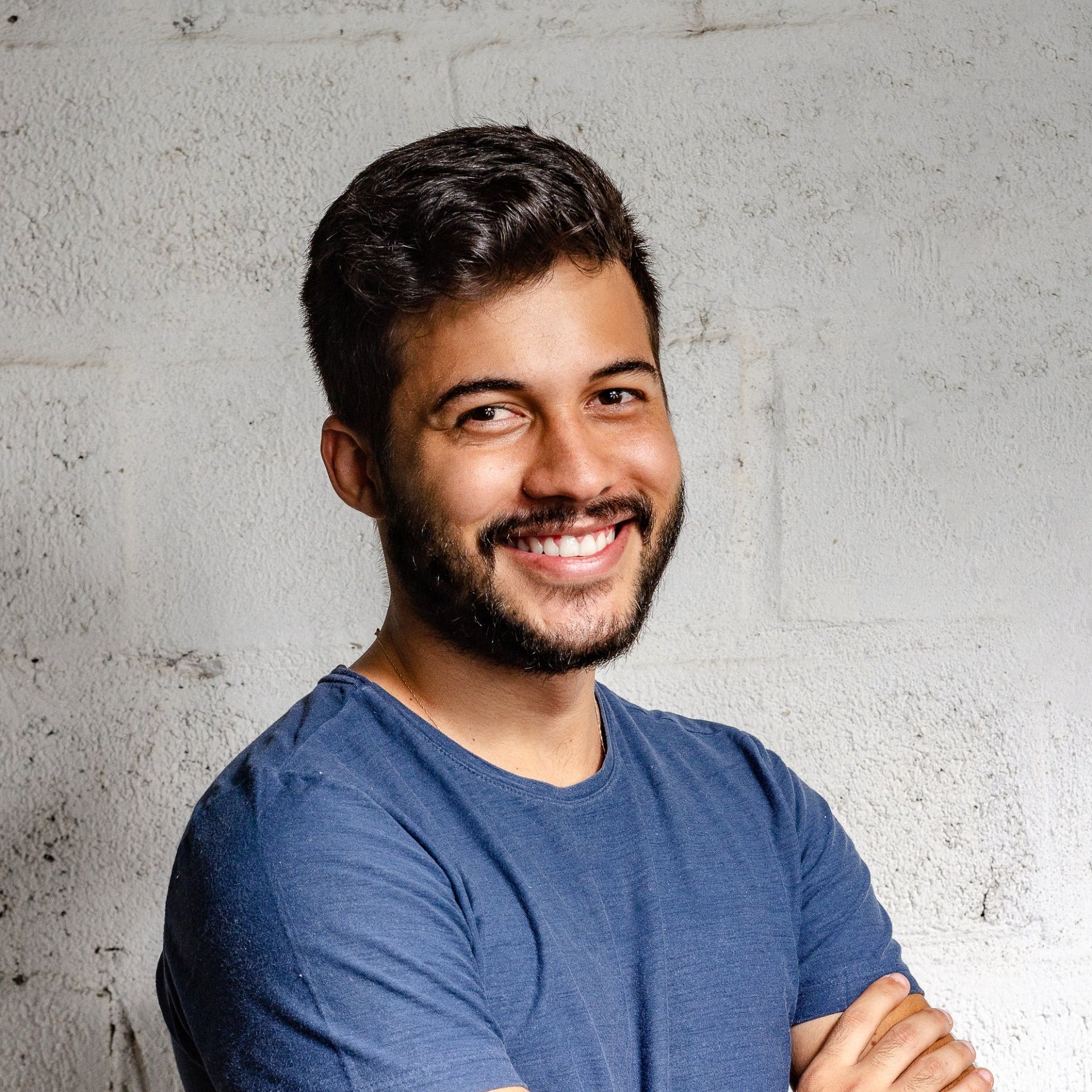 a man with a beard wearing a blue shirt is smiling