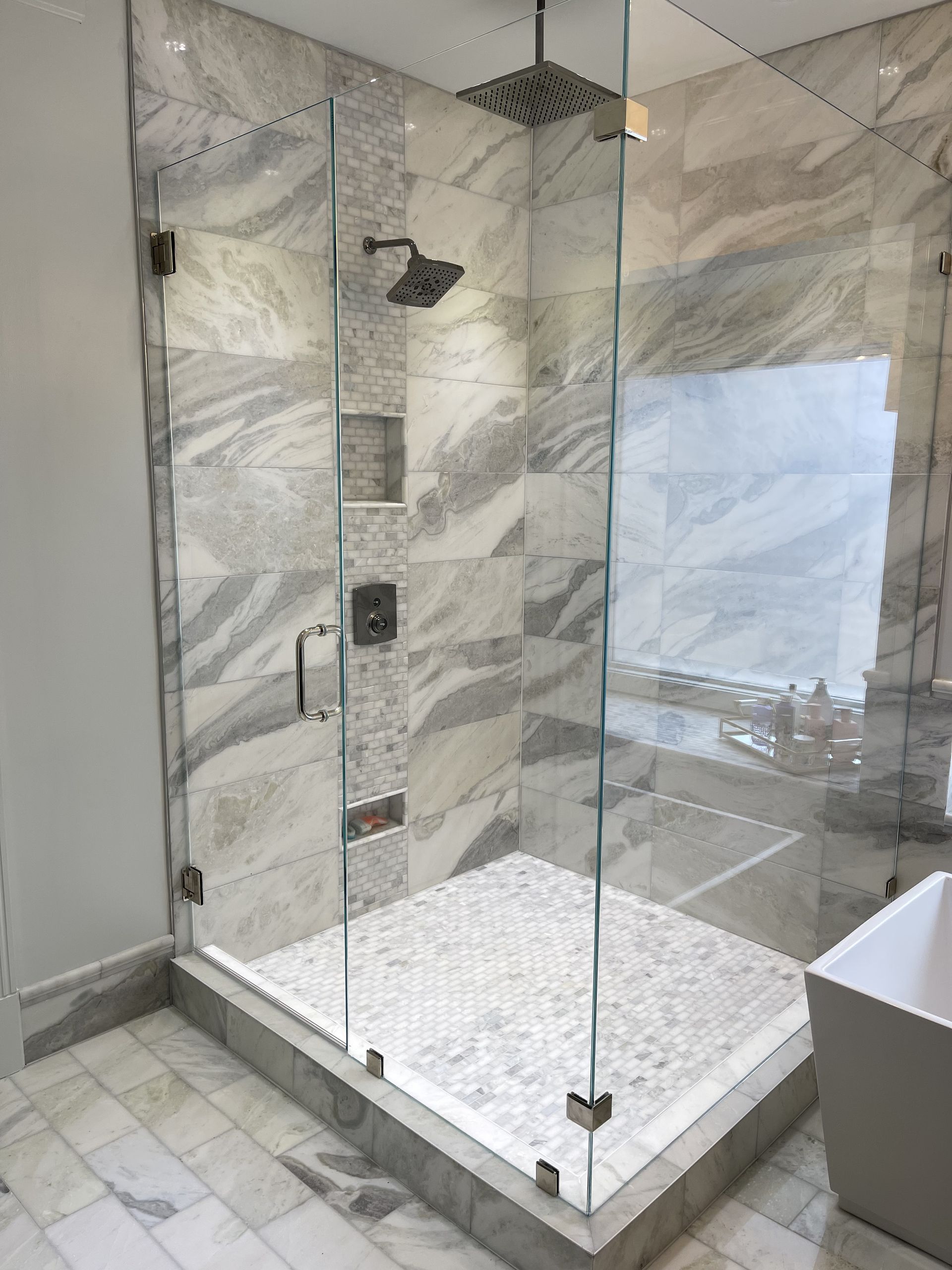 A bathroom with a walk in shower and a bathtub.