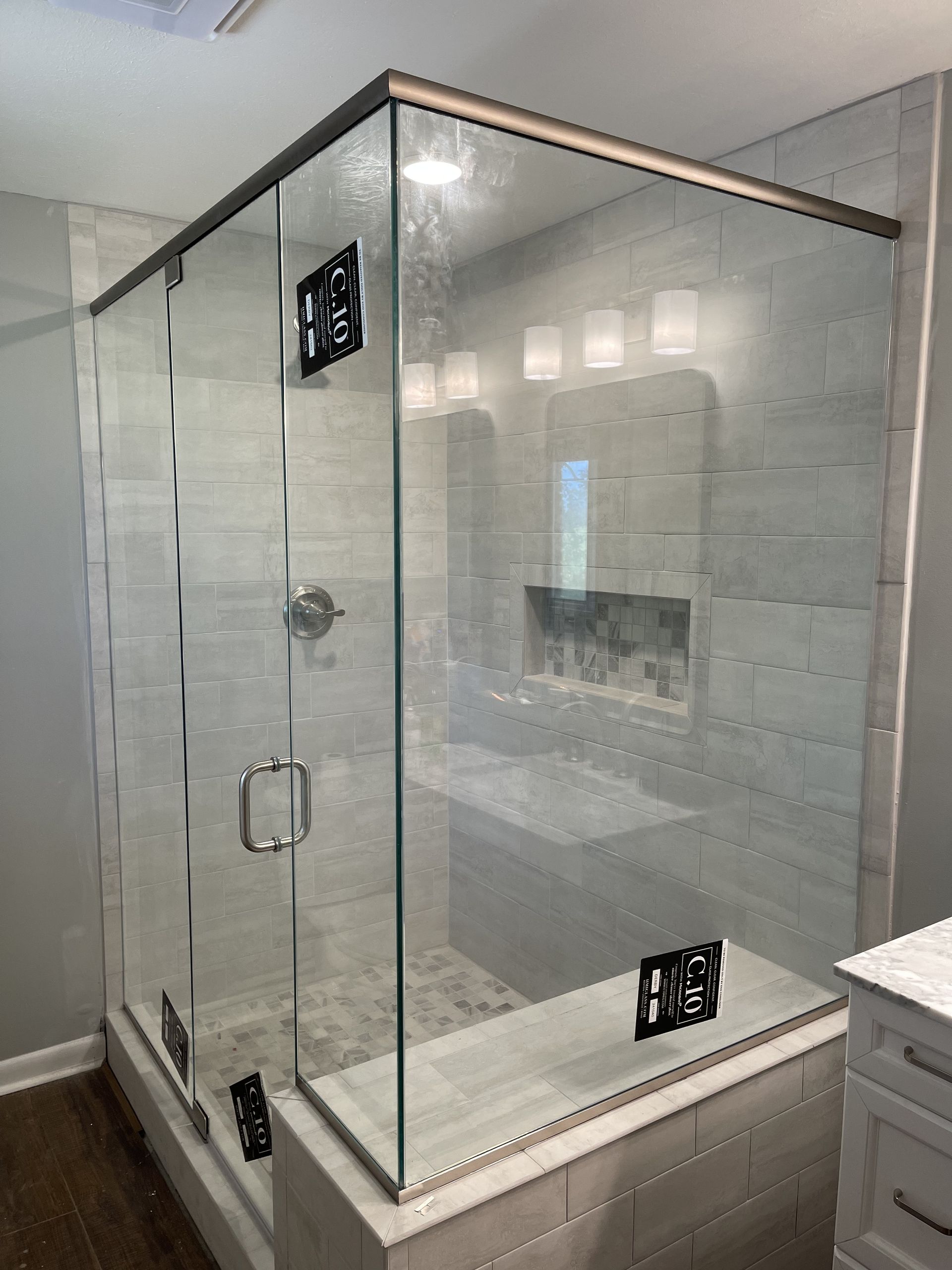 A bathroom with a glass shower door and a sink.
