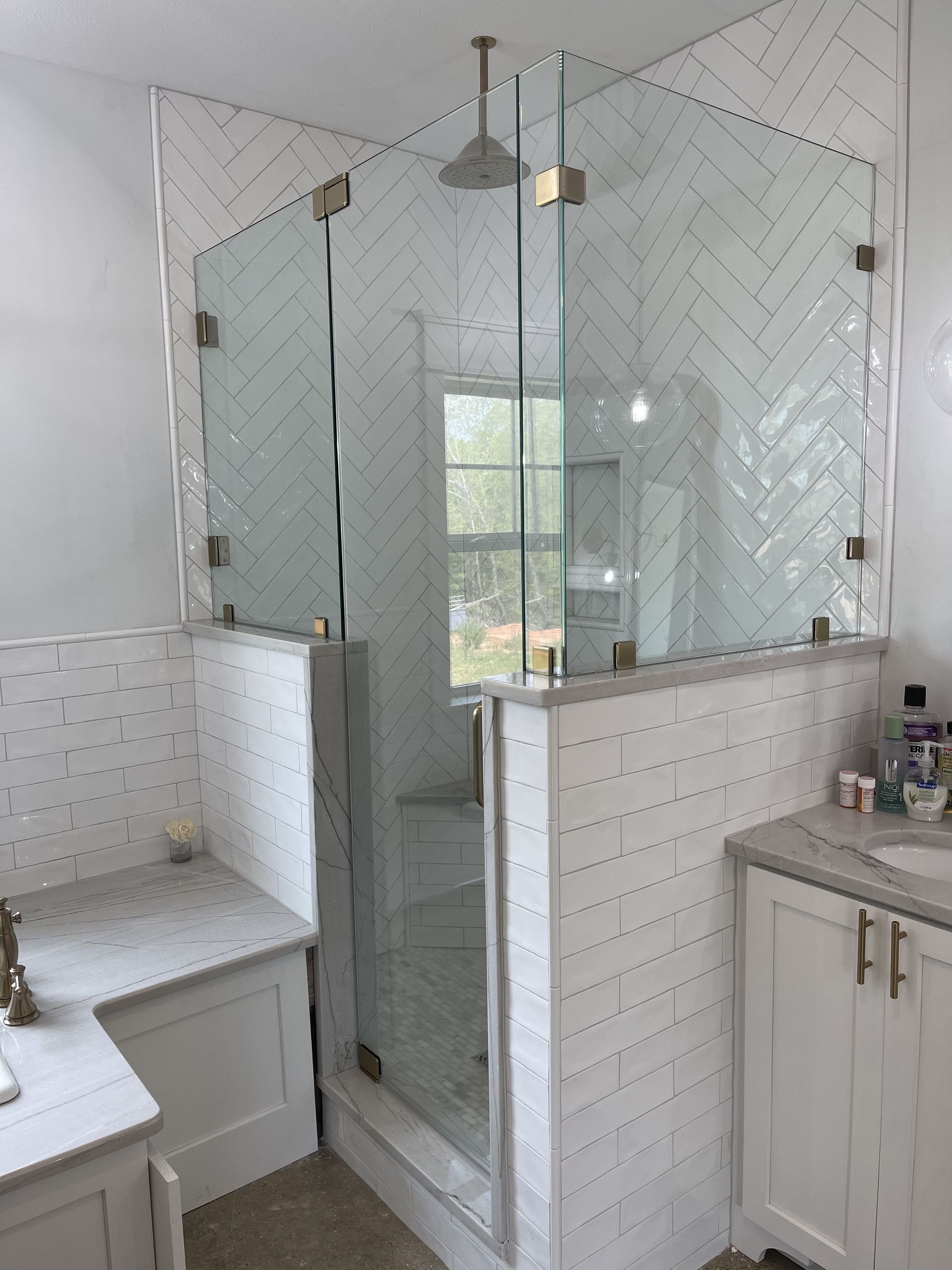 A bathroom with a walk in shower and a sink.