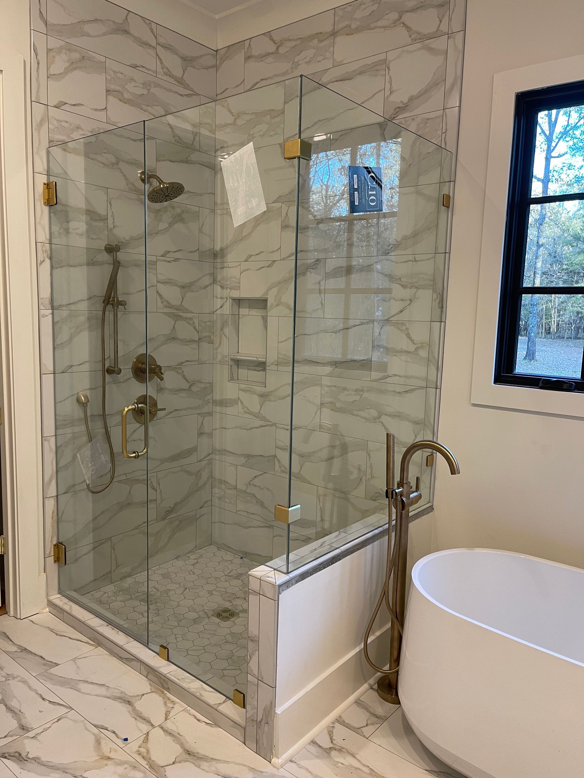 A bathroom with a walk in shower and a bathtub.