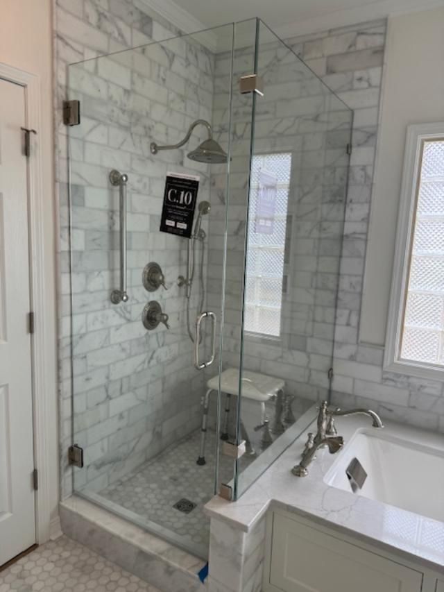 A bathroom with a walk in shower and a tub.