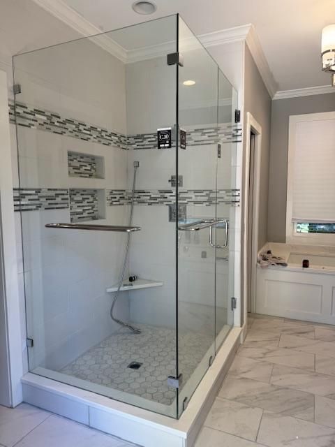 A bathroom with a walk in shower and a tub