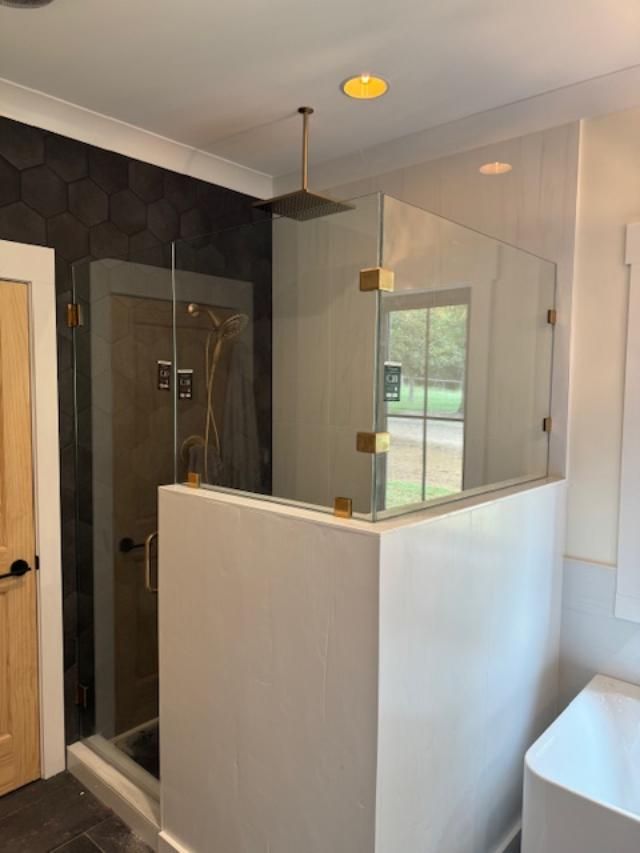 A bathroom with a walk in shower and a bathtub.