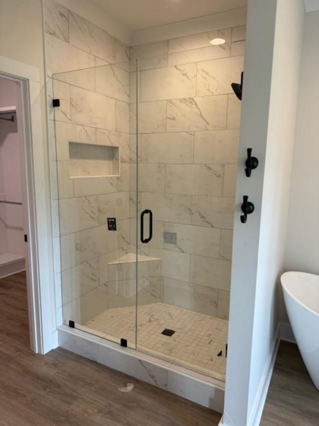 A bathroom with a walk in shower and a bathtub.