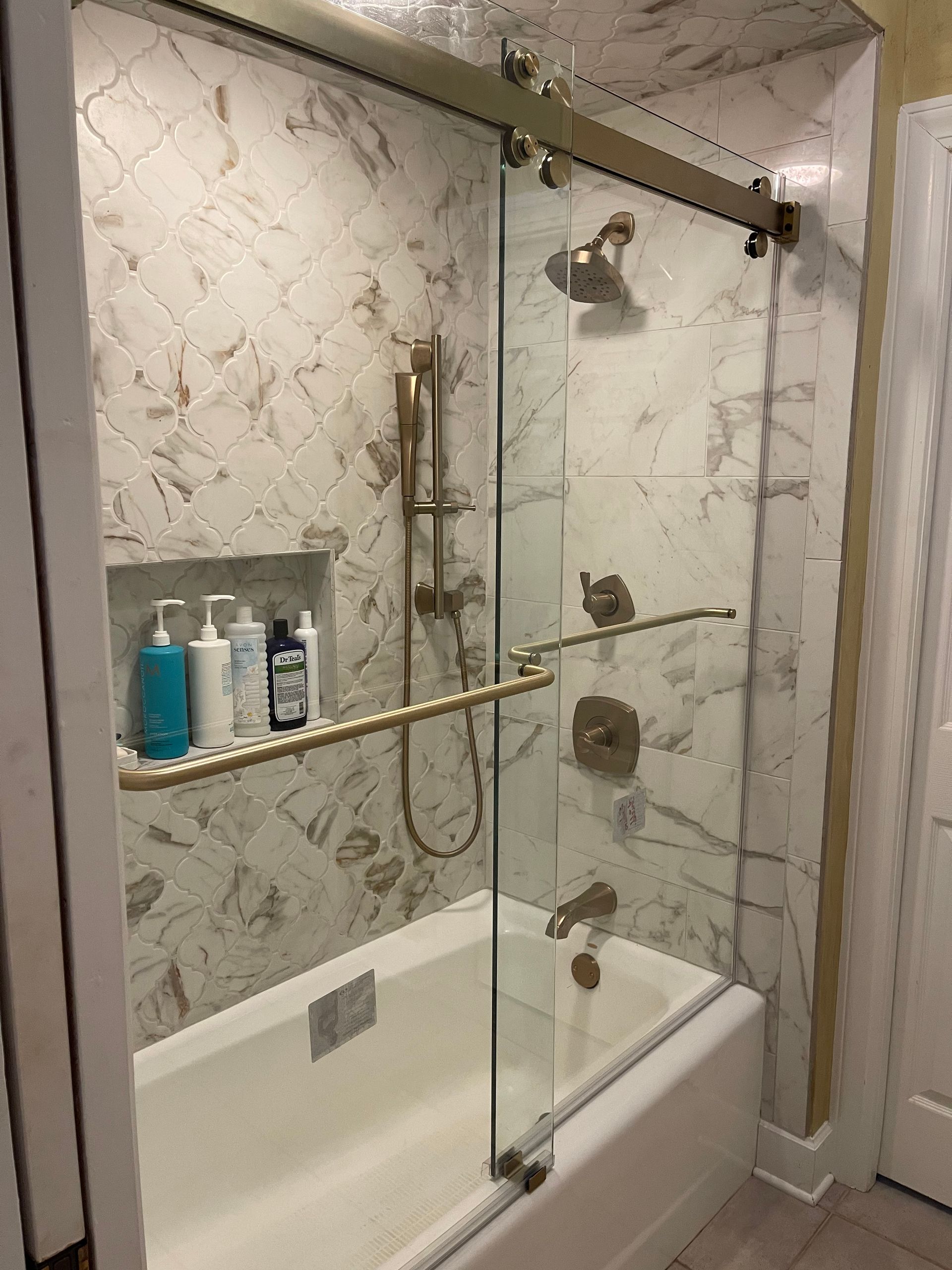 A bathroom with a bathtub and a shower with a glass door.