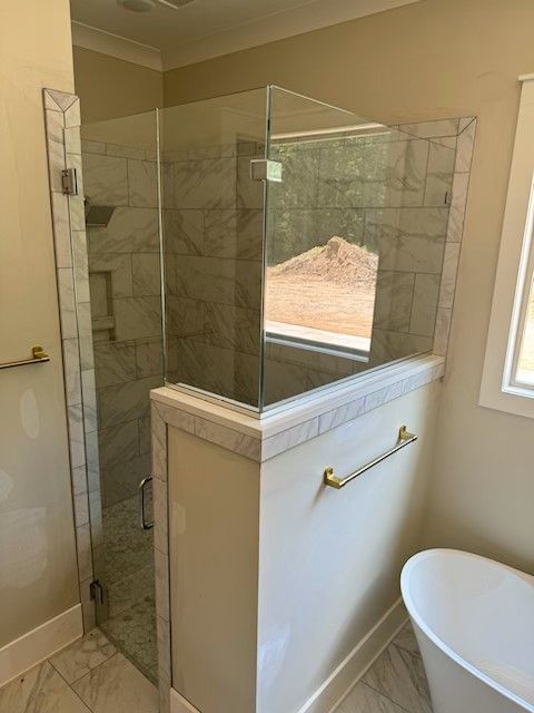 A bathroom with a walk in shower and a bathtub.