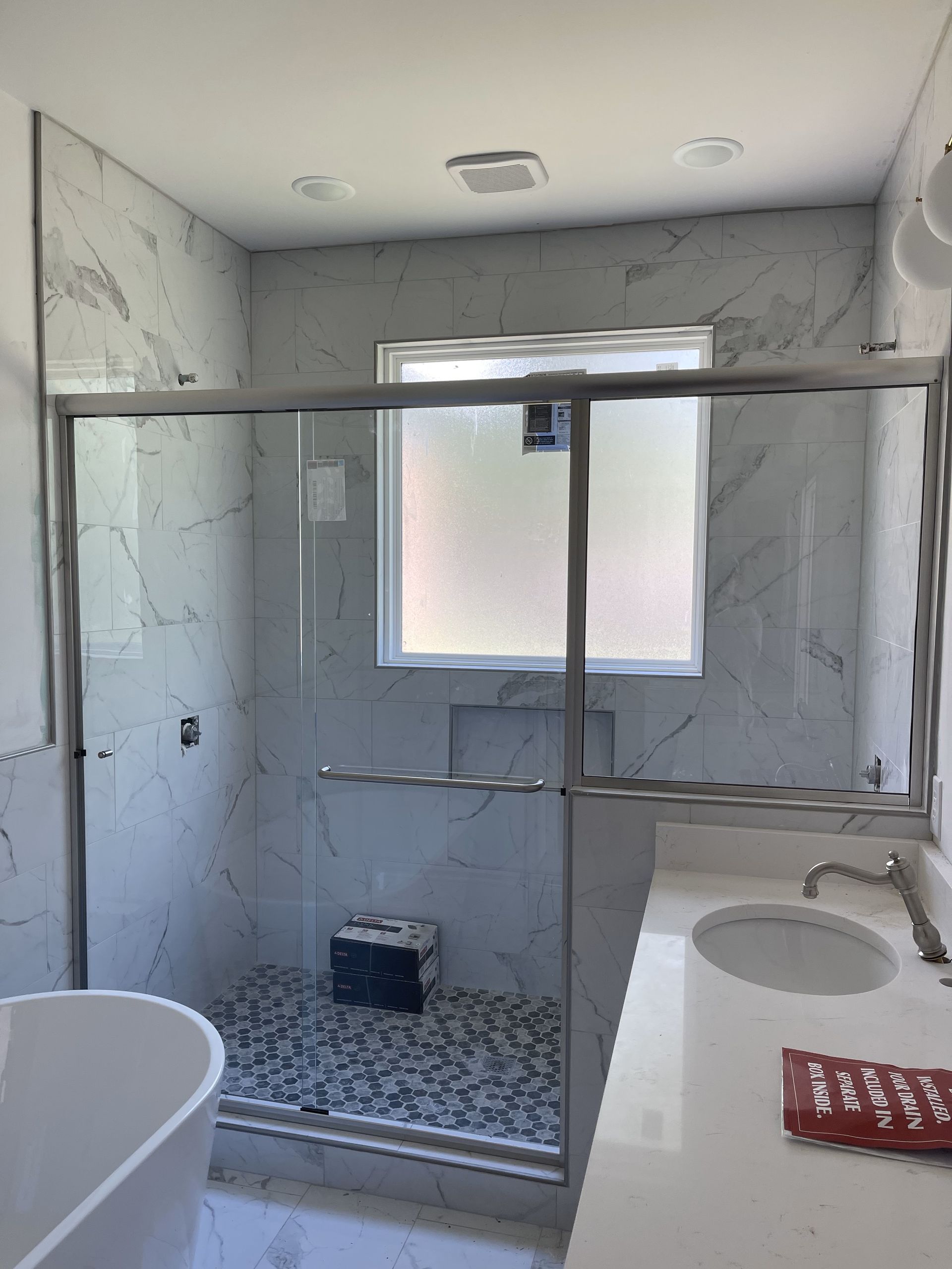 A bathroom with a tub , sink , and shower.