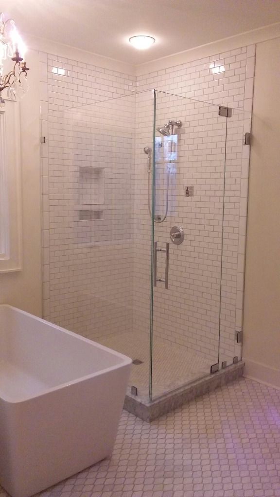 A bathroom with a bathtub and a walk in shower with a glass door.