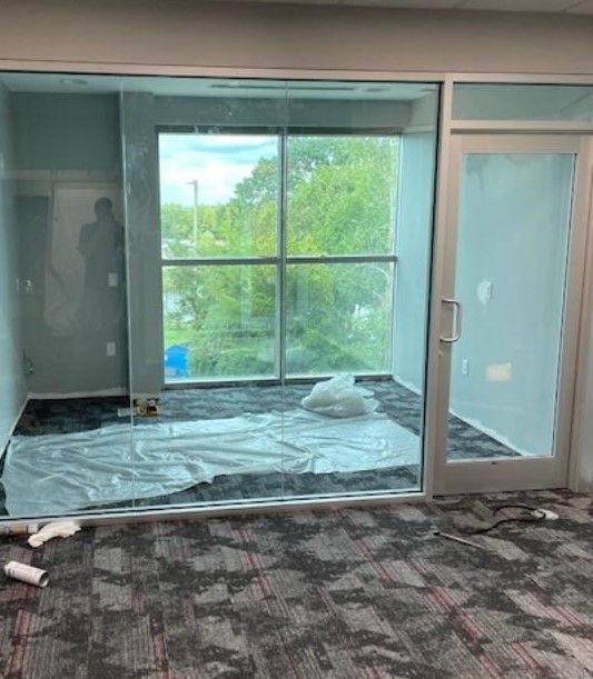 A room with a lot of windows and a carpeted floor.