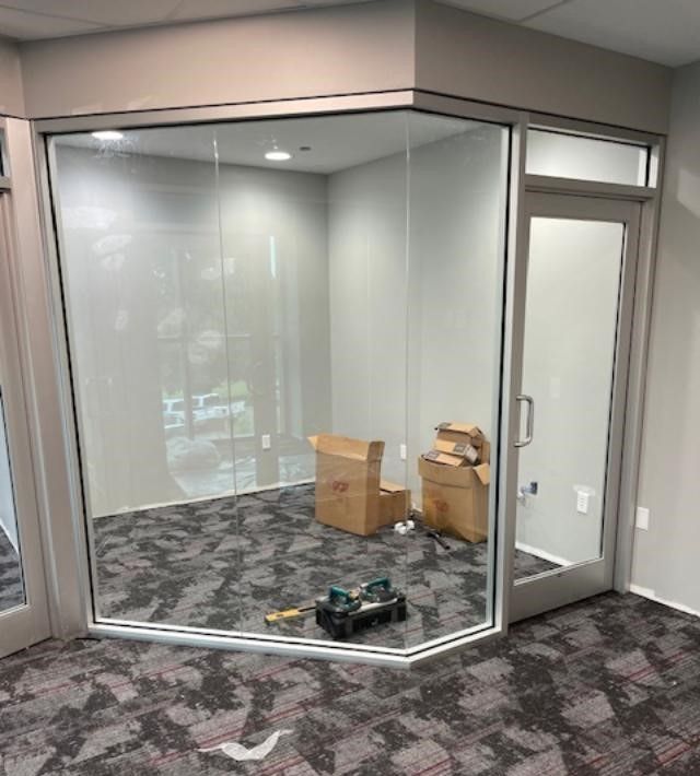 A room with a lot of windows and boxes on the floor.