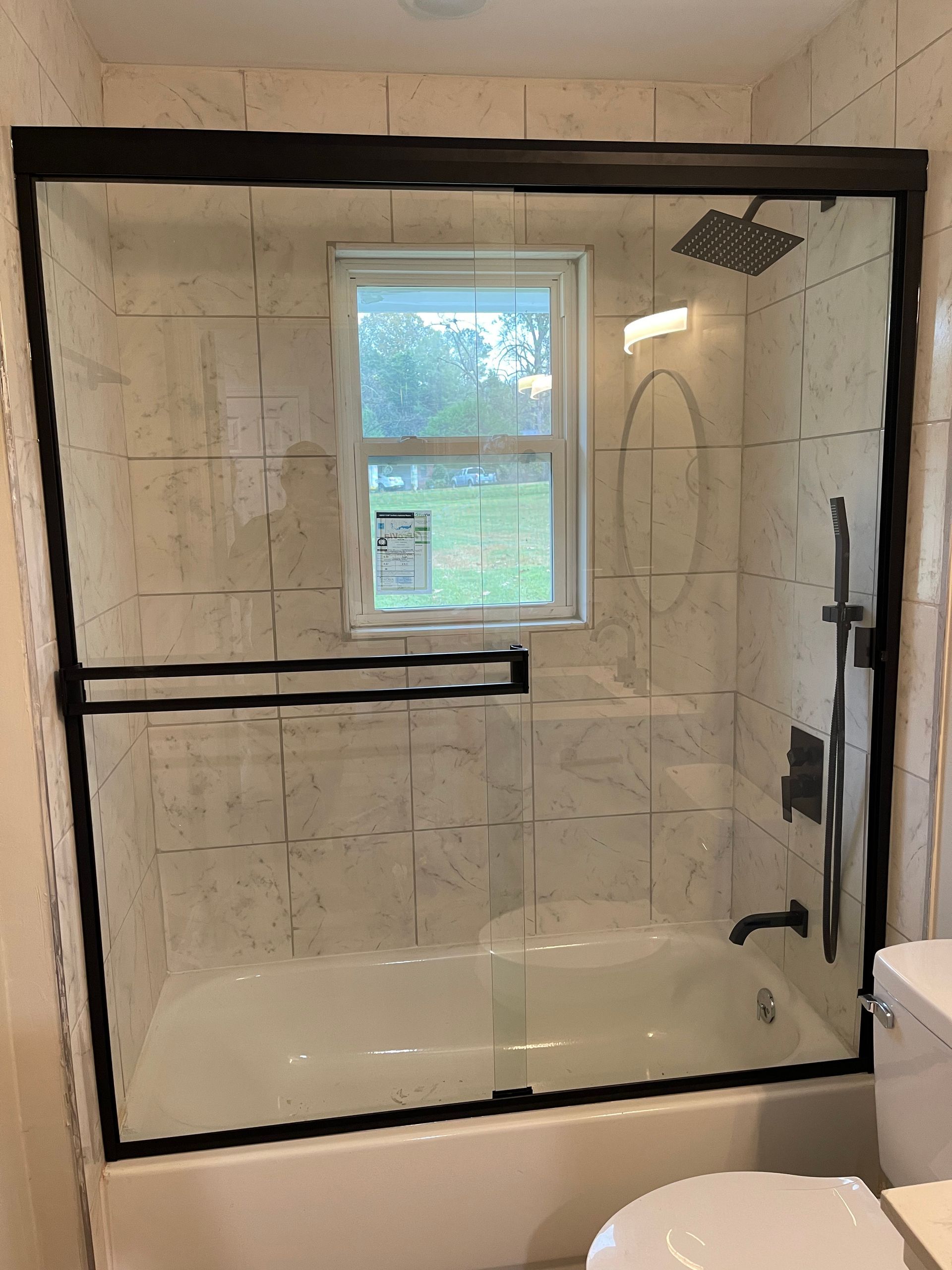 A bathroom with a bathtub , toilet , shower and window.