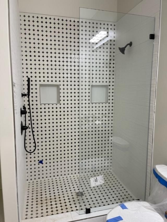 A bathroom with a walk in shower and a toilet