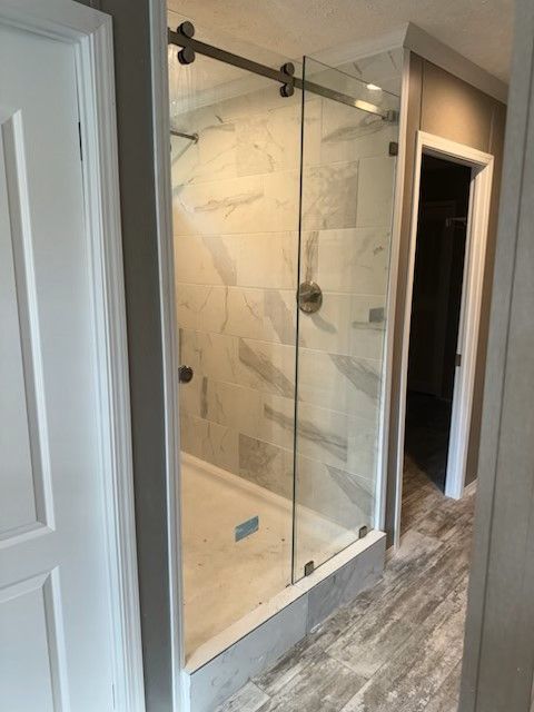 A bathroom with a sliding glass shower door