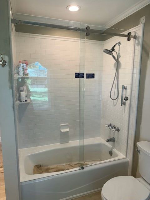 A bathroom with a bathtub , toilet and shower.