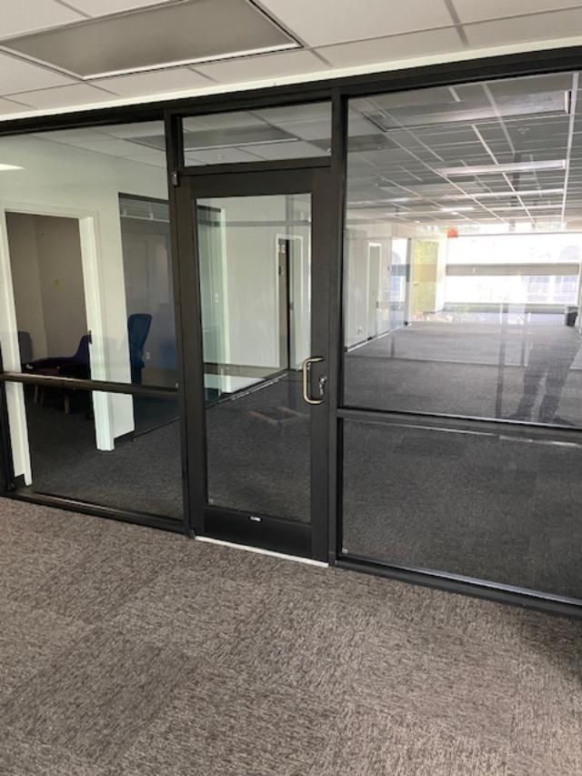 A large room with a glass door and a carpeted floor.