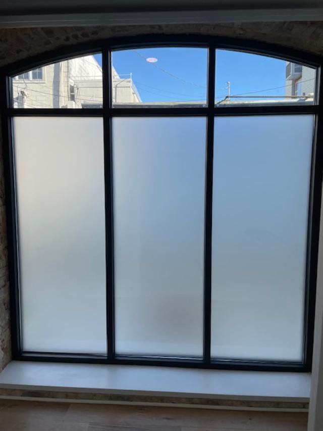 A large window with a black frame and frosted glass.