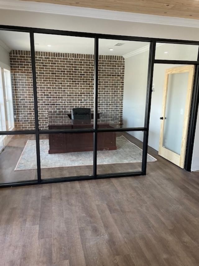 A room with a brick wall and a desk in it