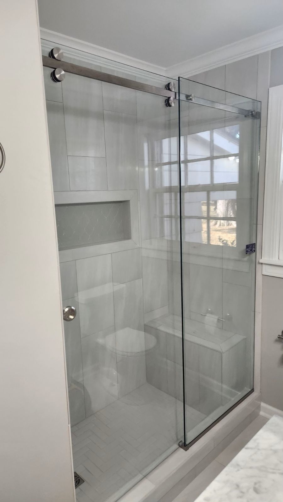 A bathroom with a sliding glass shower door and a toilet.