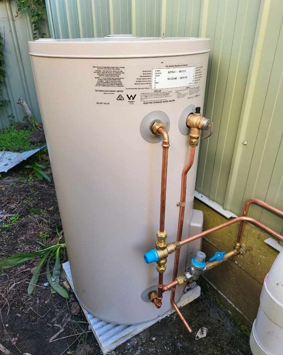 A White Water Heater With Copper Pipes Attached to It — JMJ Plumbing & Drainage In Tumbi Umbi, NSW